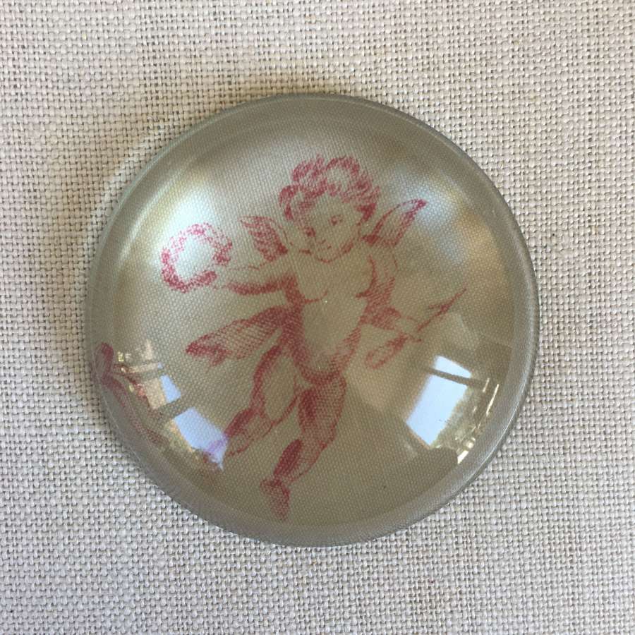 Vintage domed glass paperweight of toile cherub