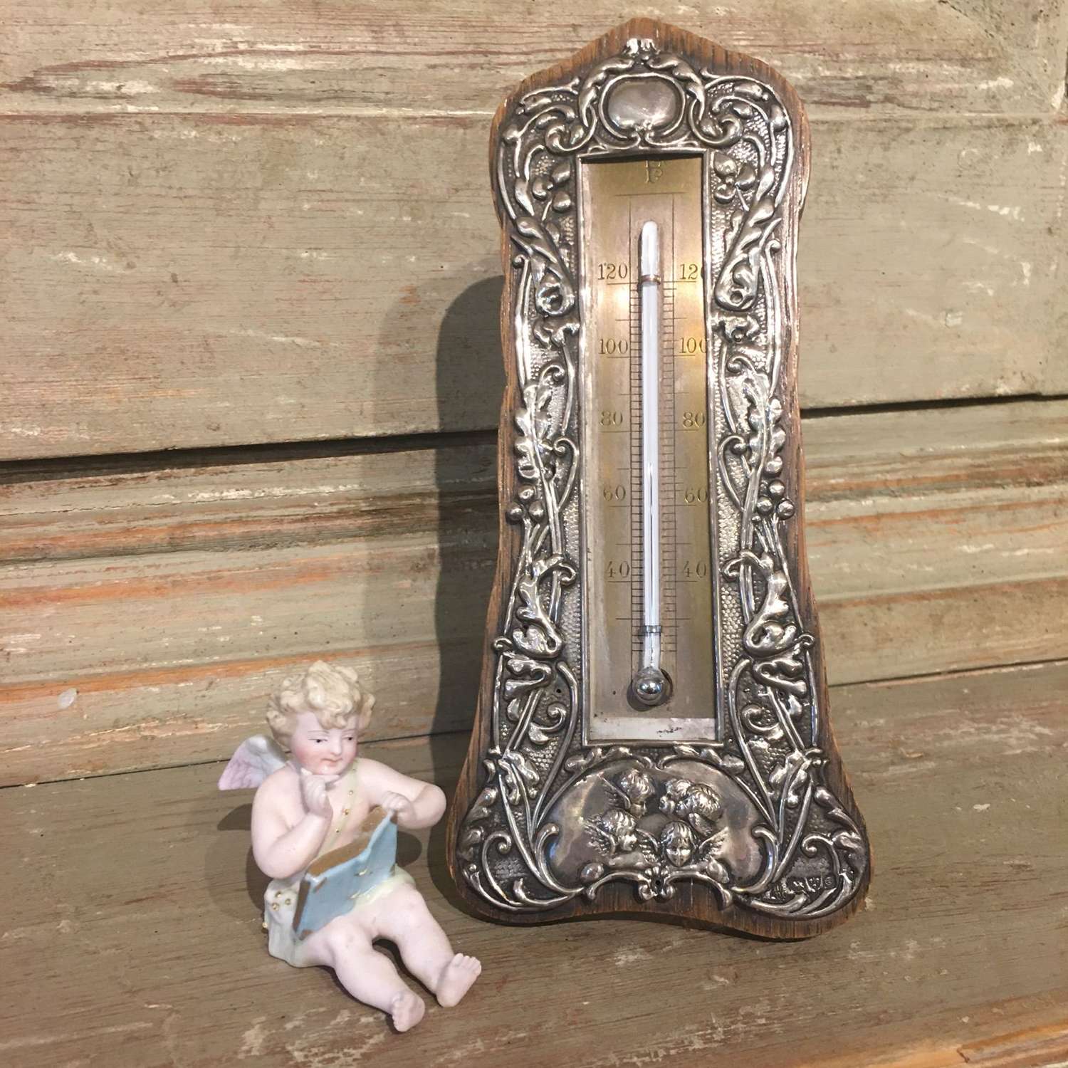 An antique silver thermometer d 1904 with cherub design