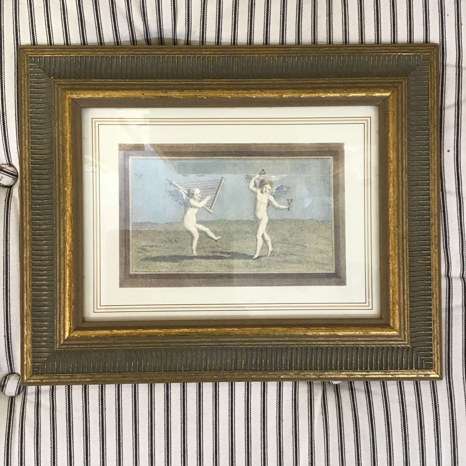 Giltwood framed print of two cherubs playing musical instruments