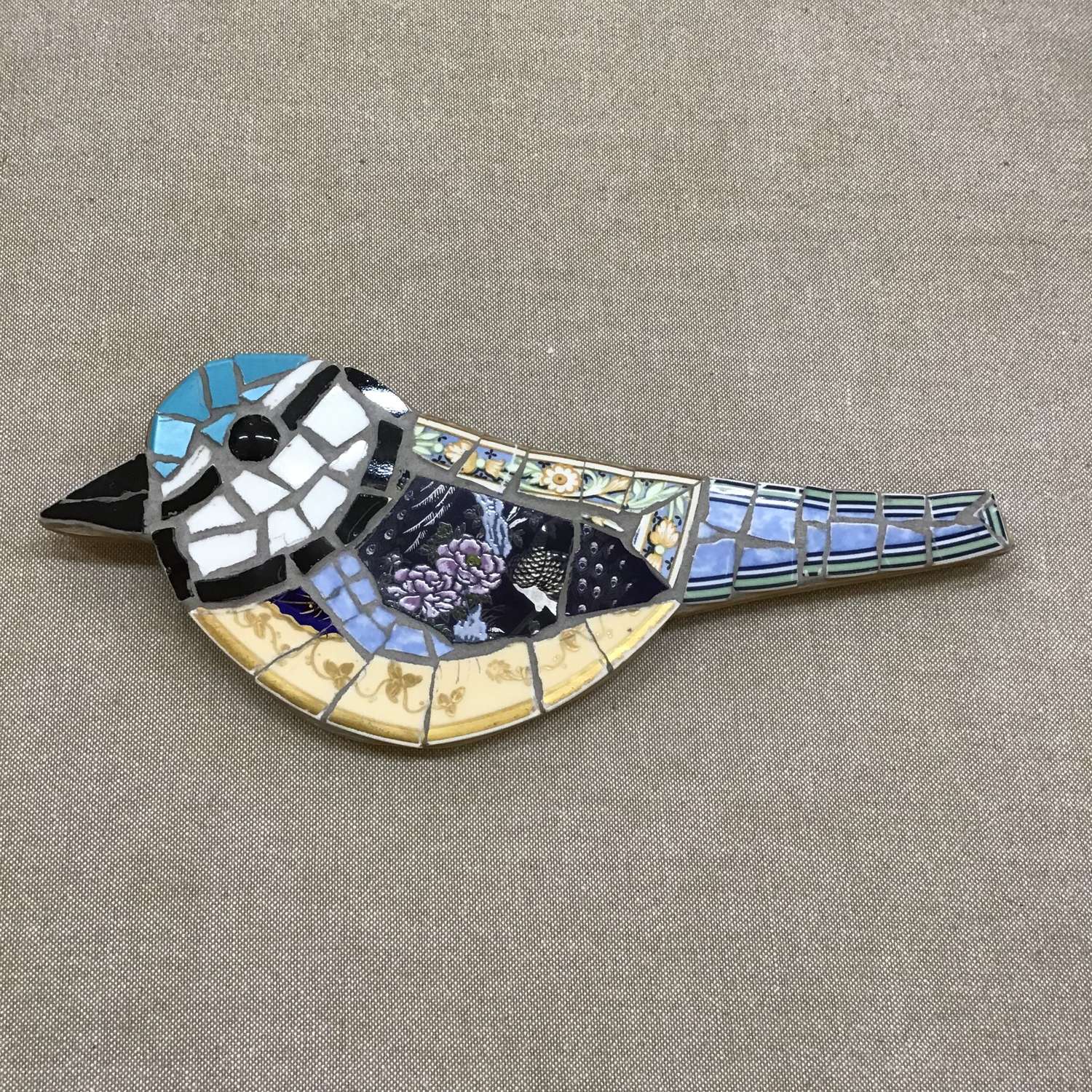 Hand crafted mosaic bird using vintage and antique china on wood