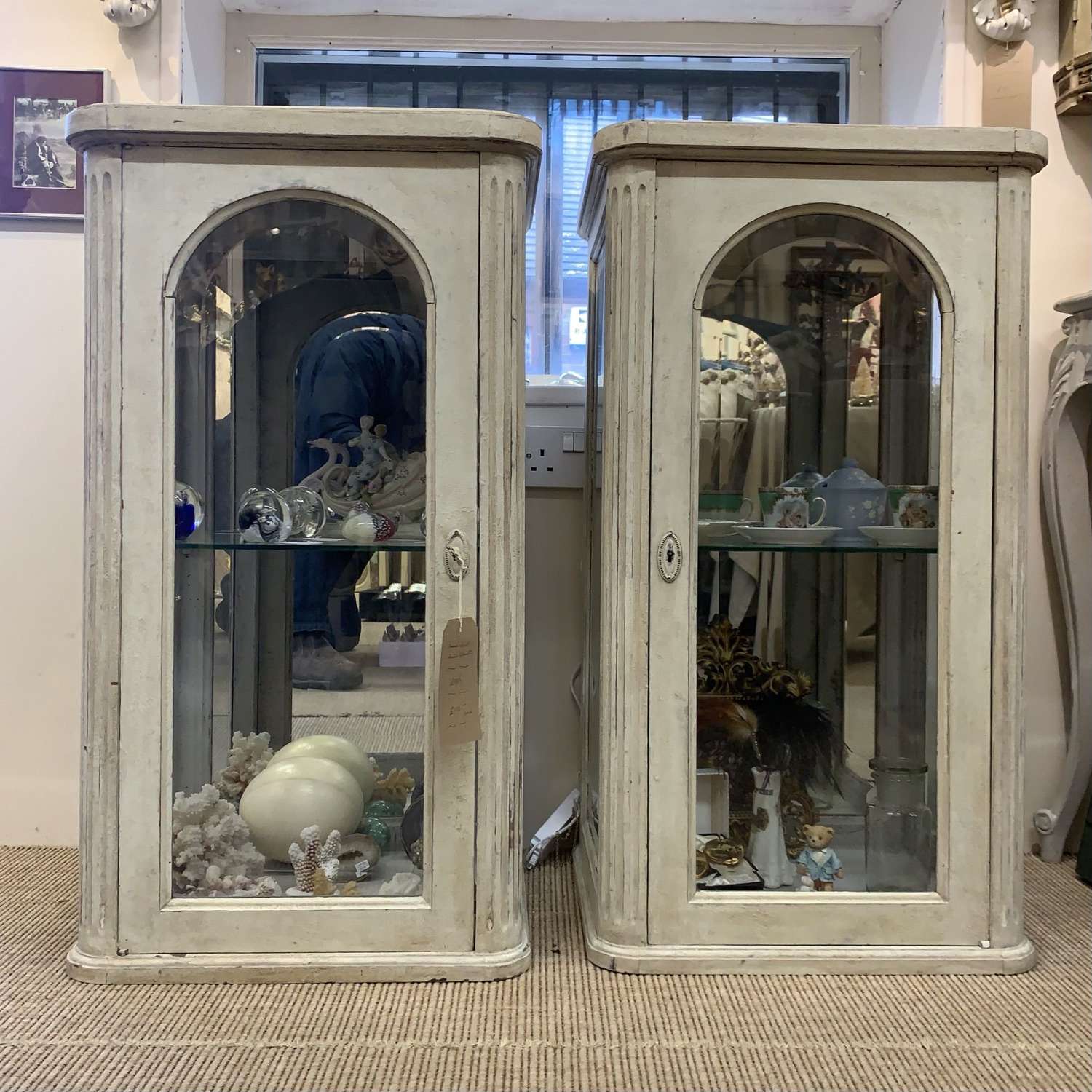 Pair of glass fronted French painted mirror backed cabinets