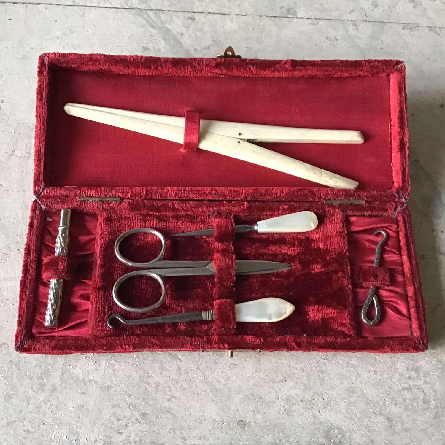 Red velvet time worn sewing kit with sewing implements
