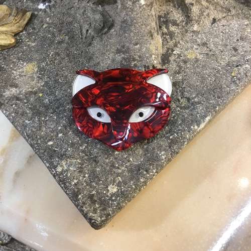 A red cat’s head brooch
