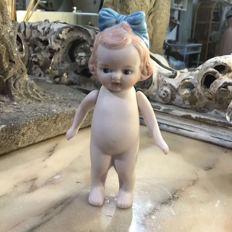 Bisque dolly with blue bow in hair and moving arms