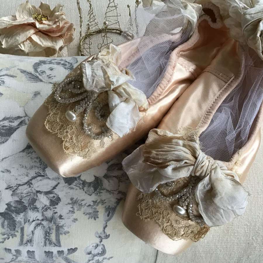 Peach ballet pointes decorated with antique lace and embellishments