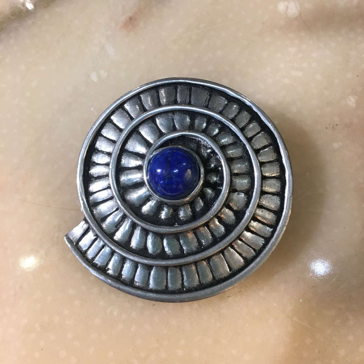 St Justin pewter and blue stone ammonite brooch