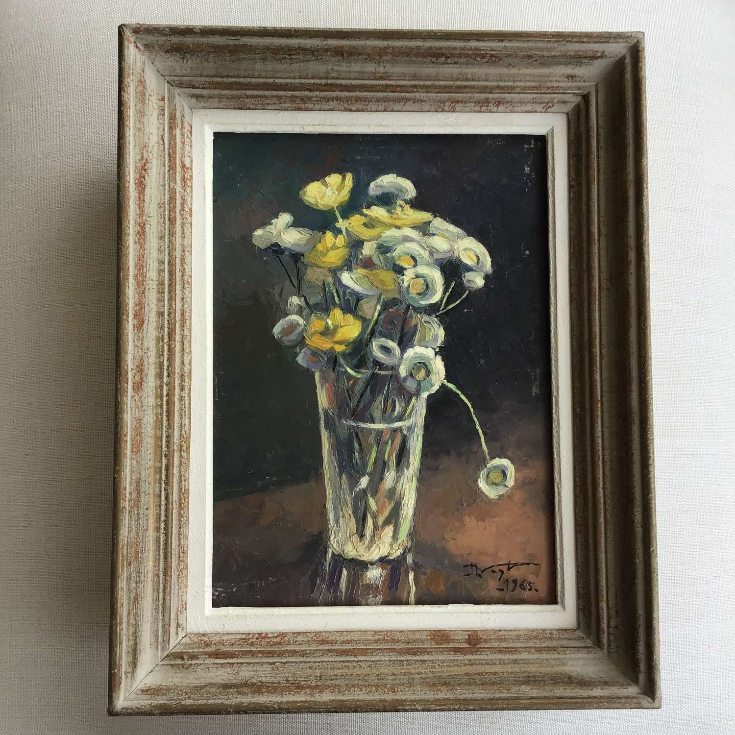 A vintage oil painting of flowers in a glass vase signed by the artist